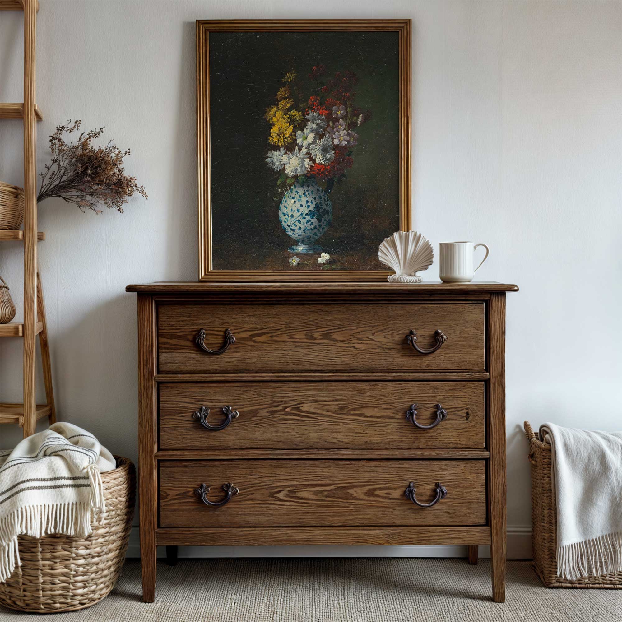 Wooden dresser with a painting of flowers above it in a room setting.