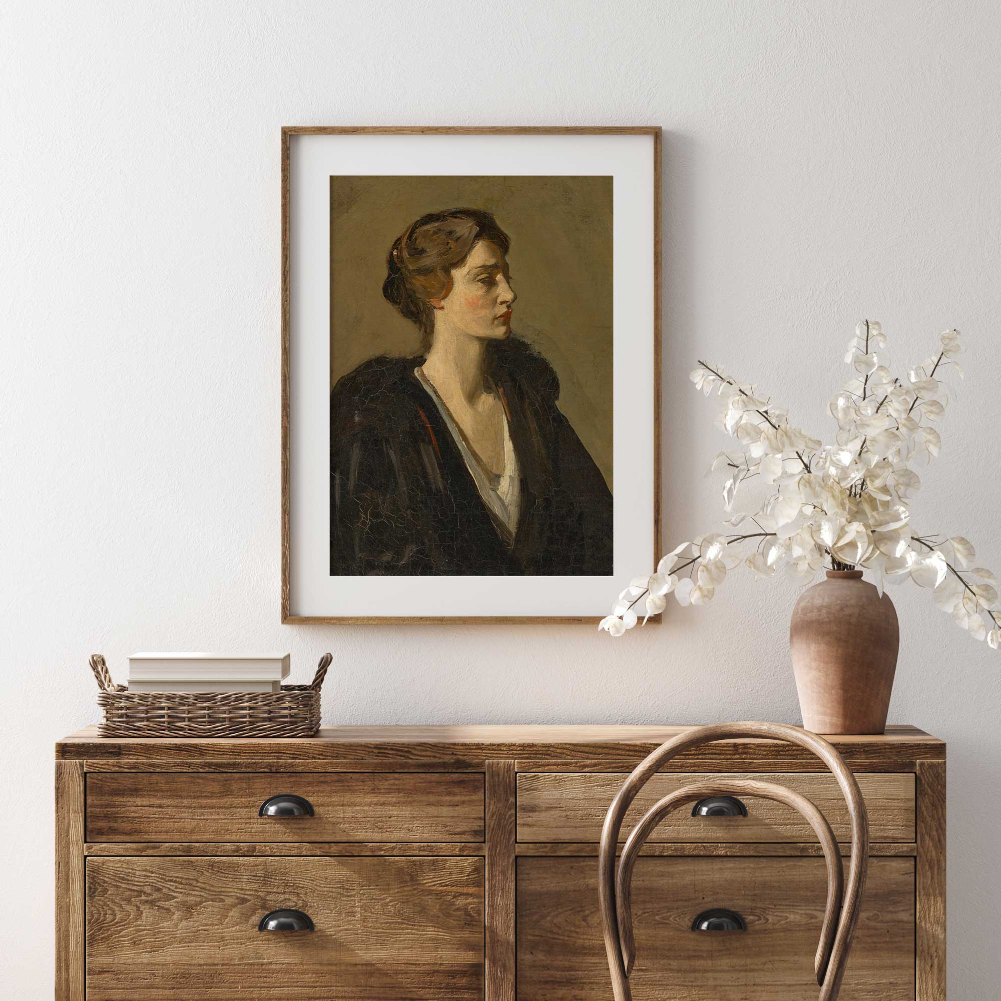Framed portrait above a wooden dresser with decorative items.
