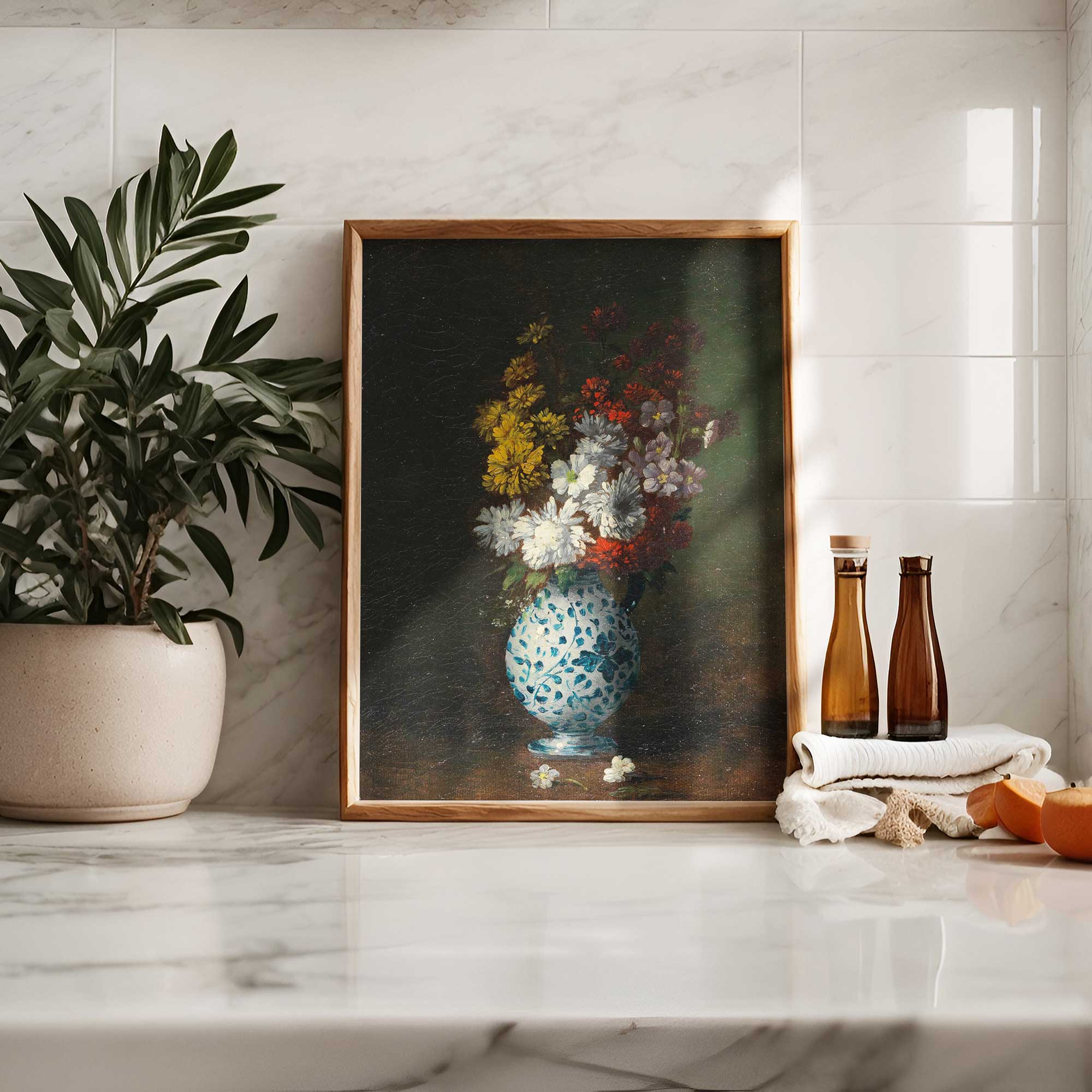 Framed painting of a floral arrangement on a marble surface with a plant and bottles in the background.
