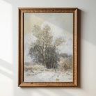 Framed painting of a winter landscape with trees on a white wall