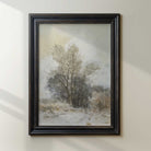 Framed painting of a winter landscape with trees on a white wall