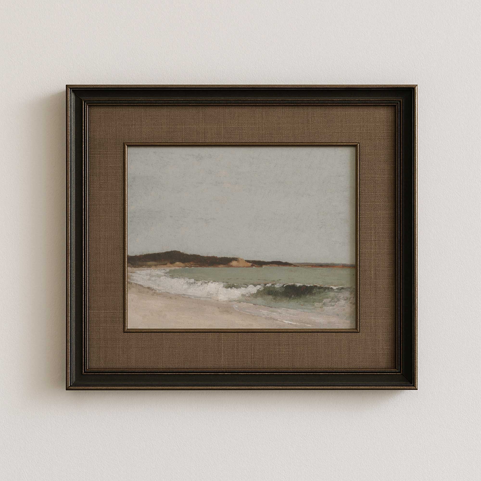 Framed artwork of a beach scene on a white wall