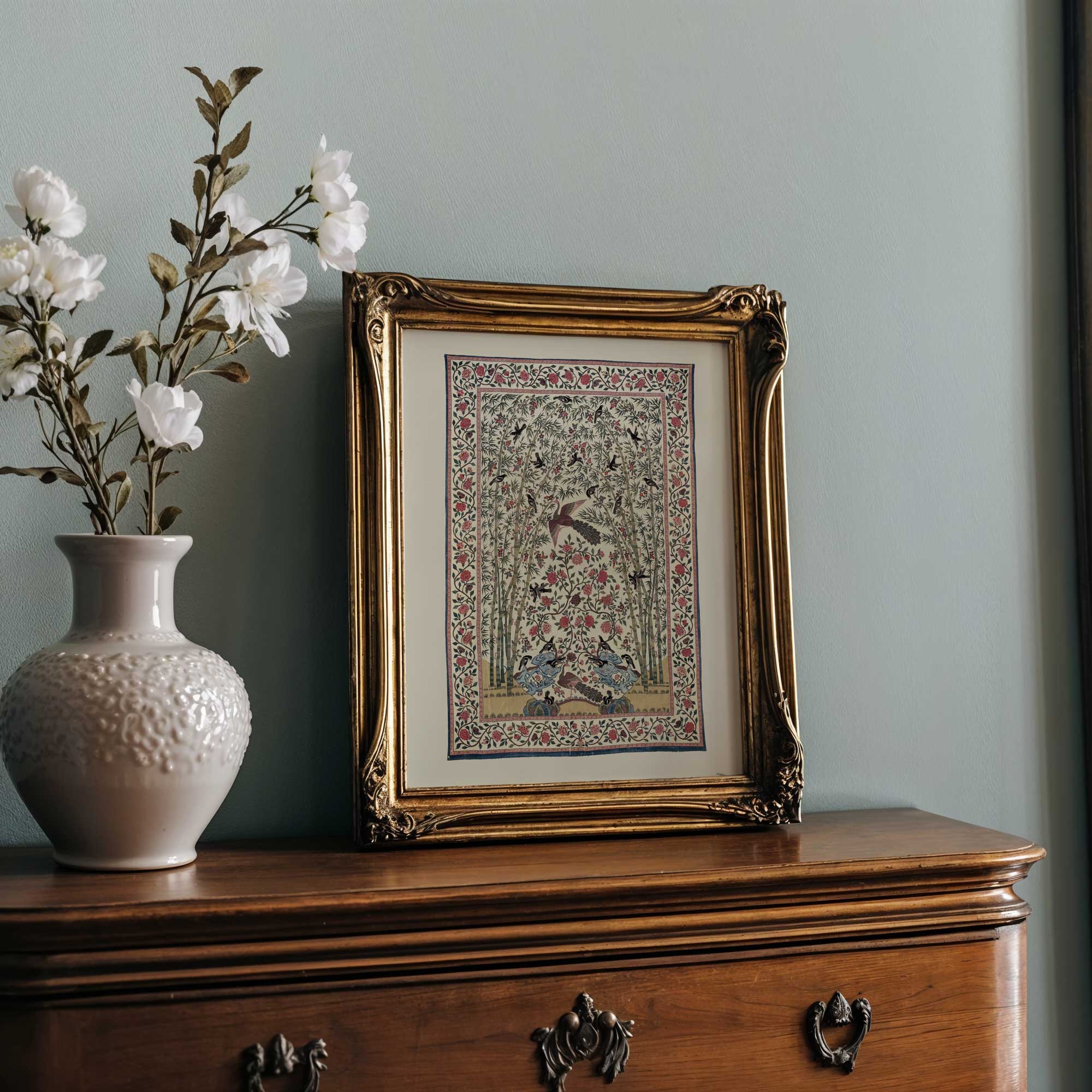 Botanical textile print with vintage bird and floral vase above wooden dresser.