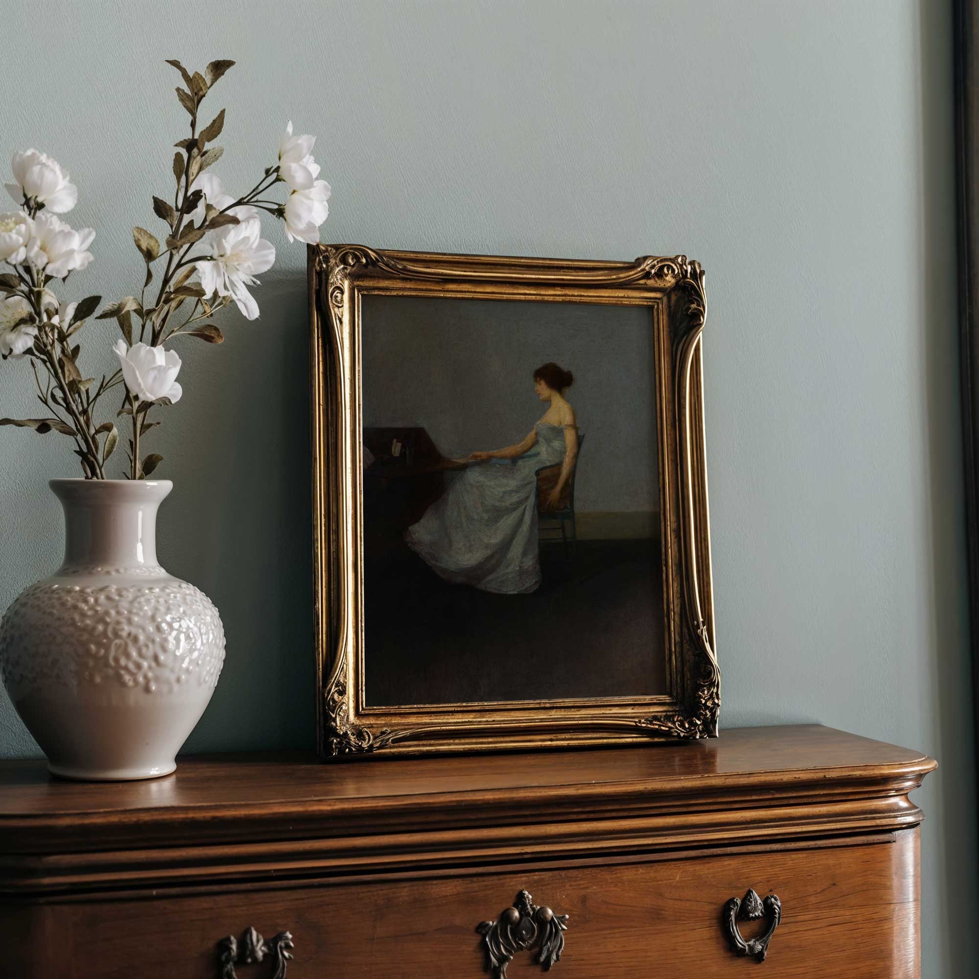 Decorative scene with a vase of flowers, framed painting, and wooden cabinet against a light blue wall.
