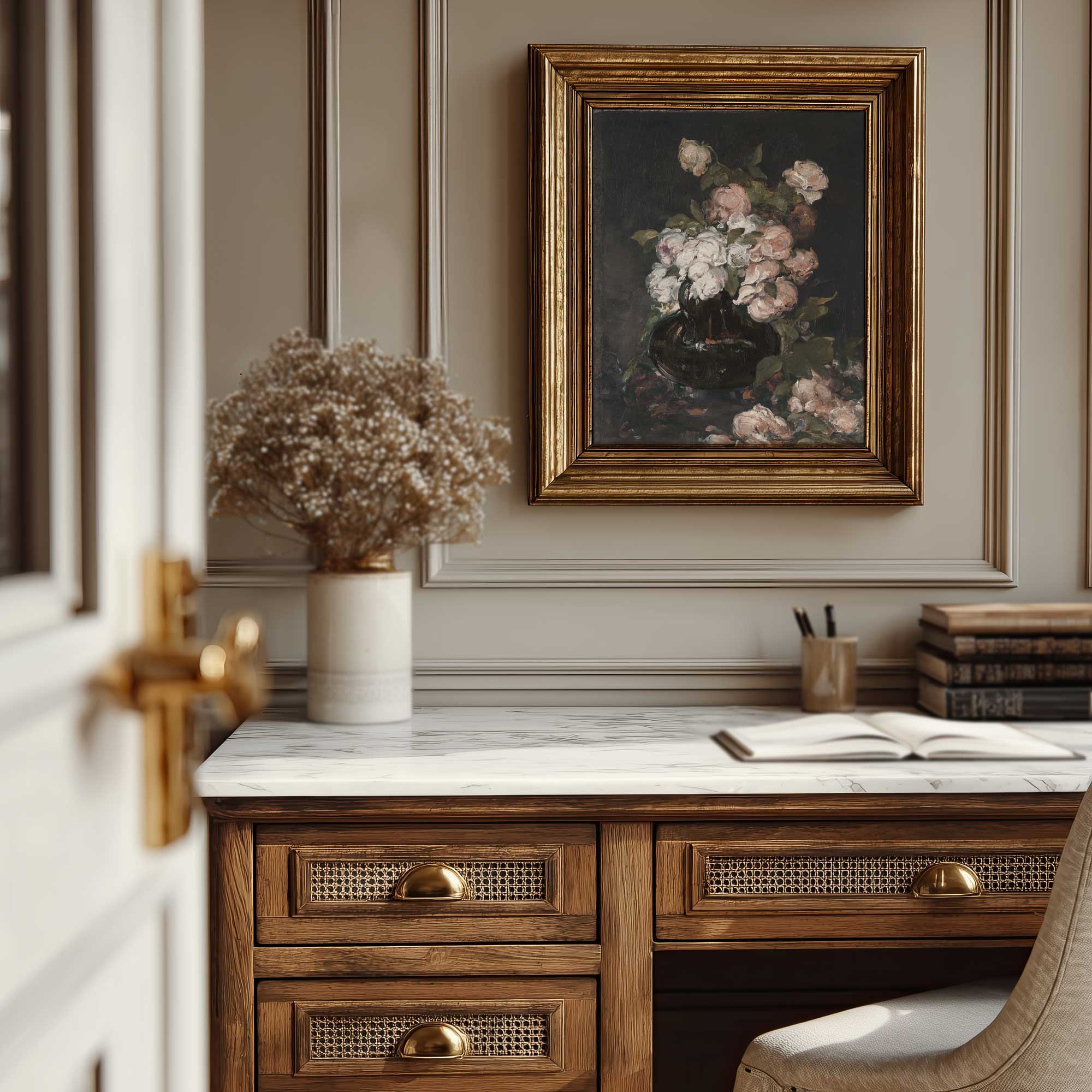 Wooden desk with marble top, vase of flowers, and framed moody floral painting in a room.