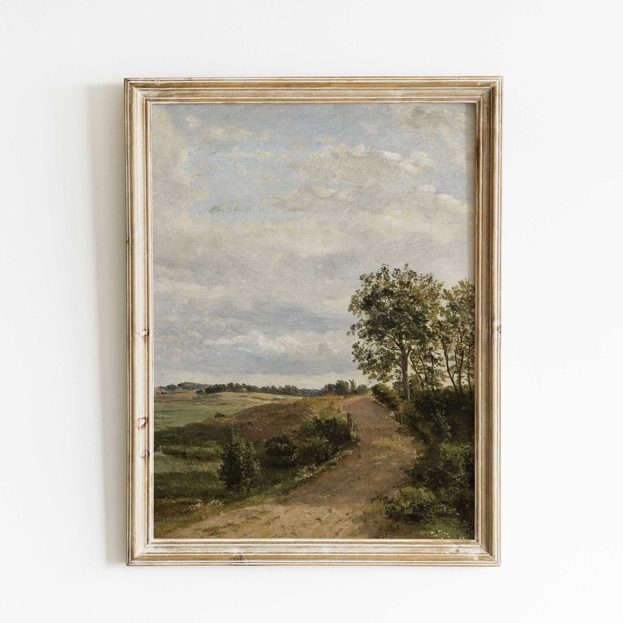 Framed vintage landscape painting print with a path and trees on a white wall