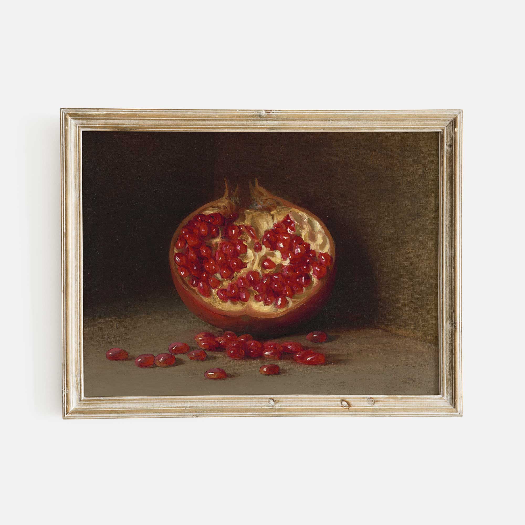 Framed painting of a pomegranate with seeds on a dark background