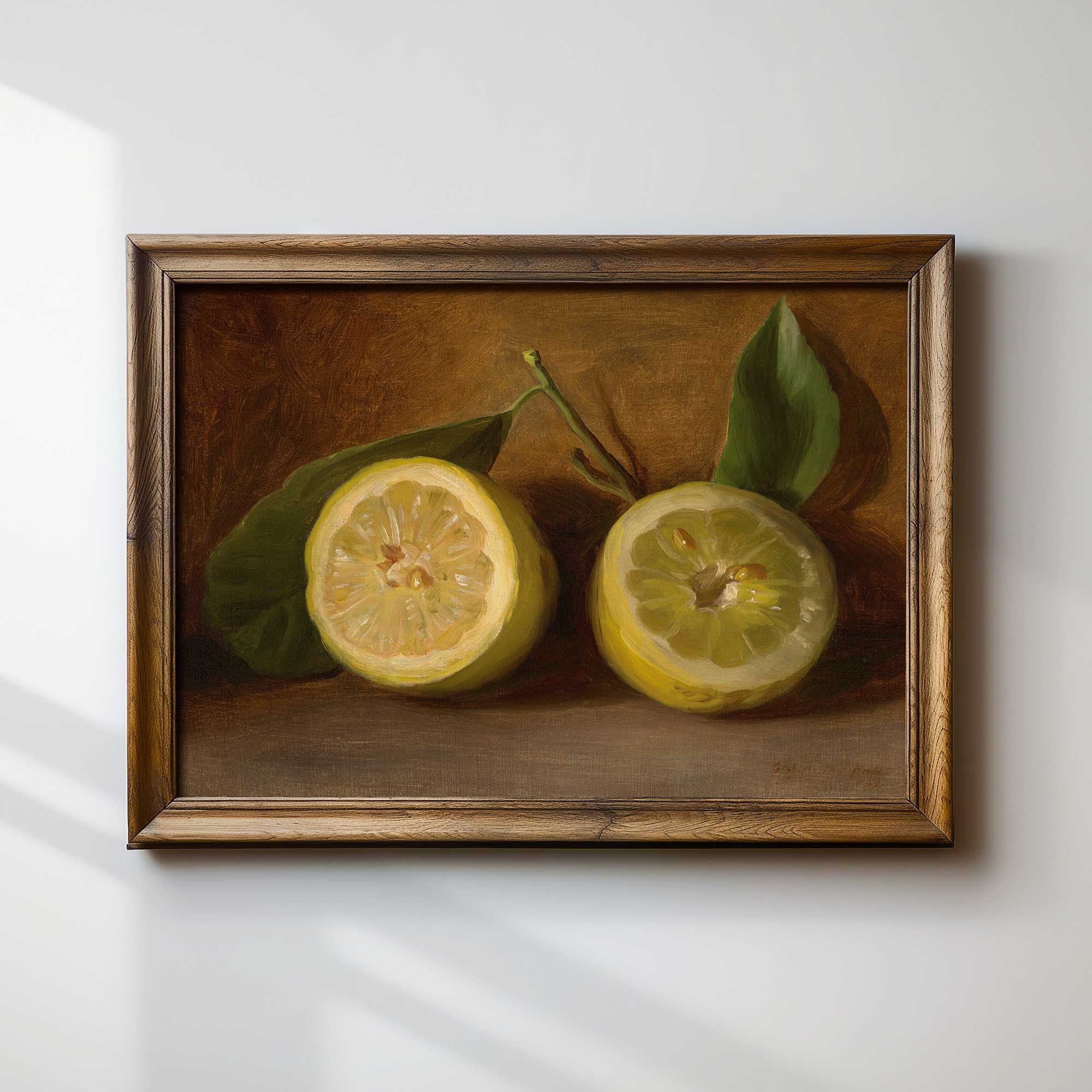 Framed painting of two lemons with green leaves on a white wall