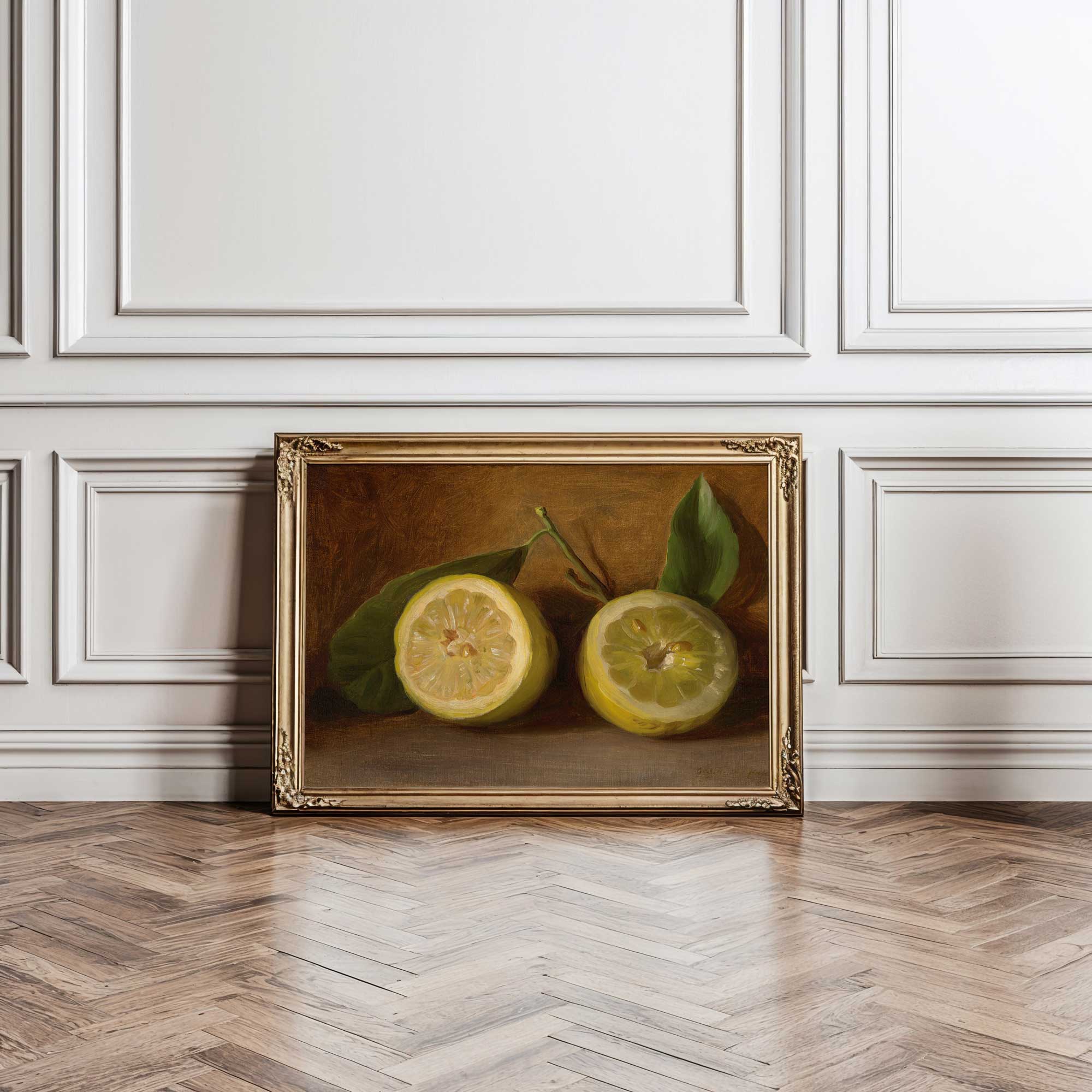 Framed artwork of two lemons on a wooden floor with white paneled walls.