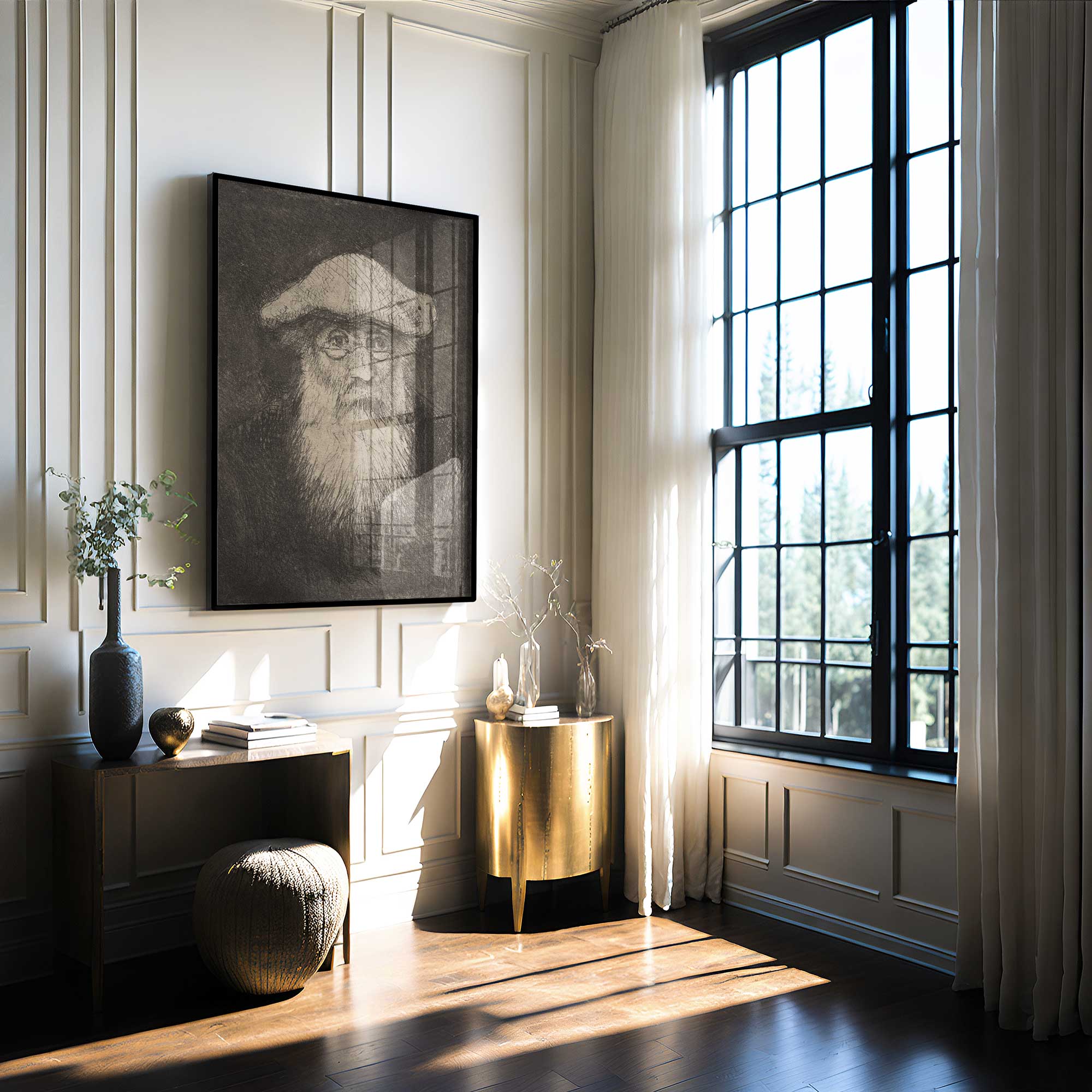Modern interior with a framed portrait of Camille Pissarro on the wall, a desk, and a large window.