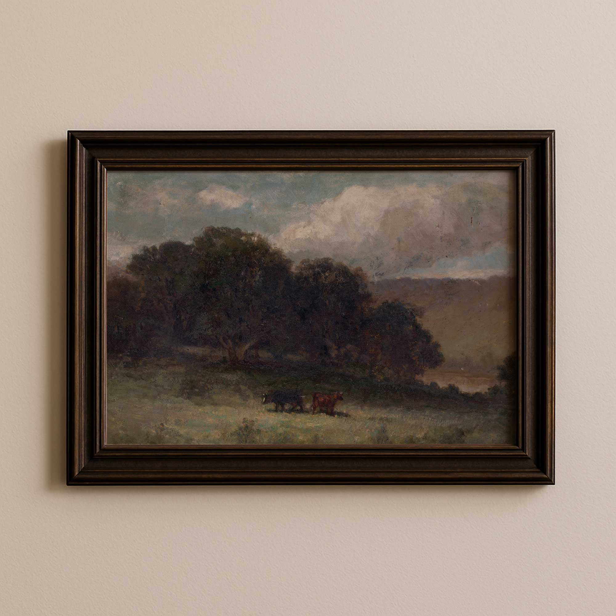 Moody farmhouse landscape print with grazing cattle in a rural meadow displayed in dark brown wood frame