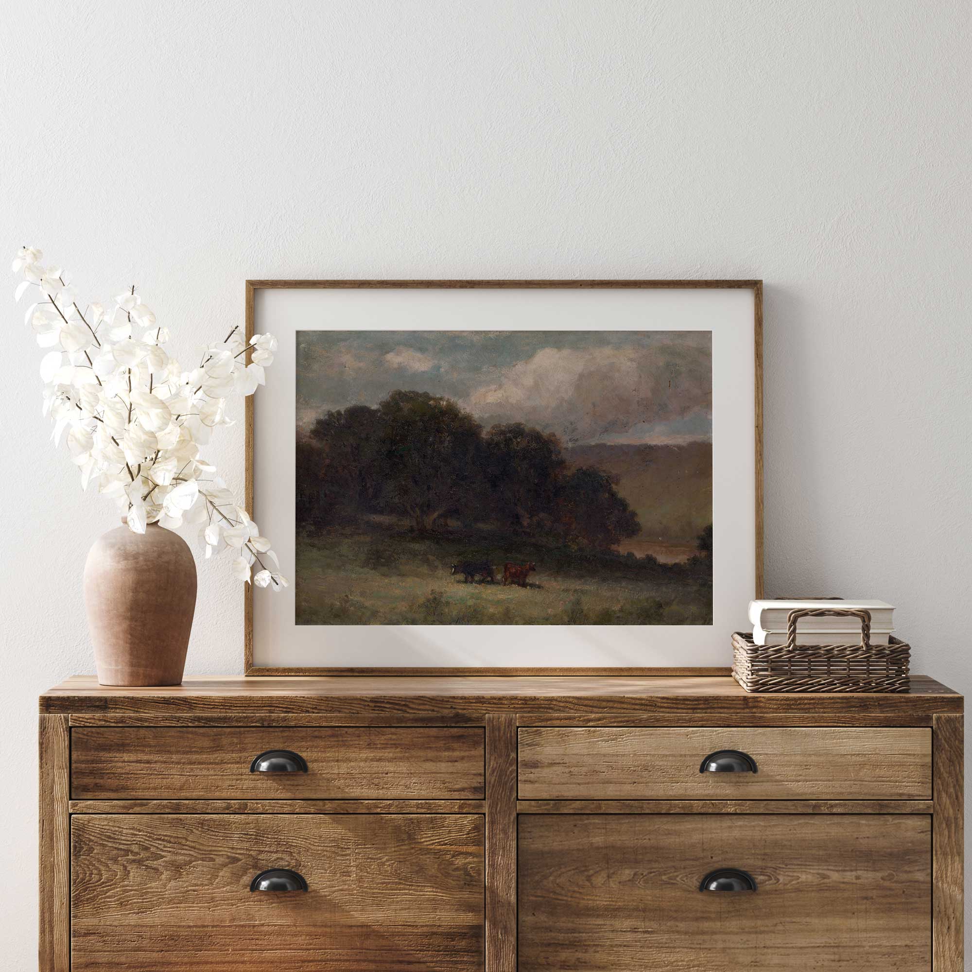 Dark country wall art displayed on a rustic farmhouse dresser with white floral arrangement and woven basket