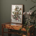 Framed botanical print on a wooden table with a dark green wall background