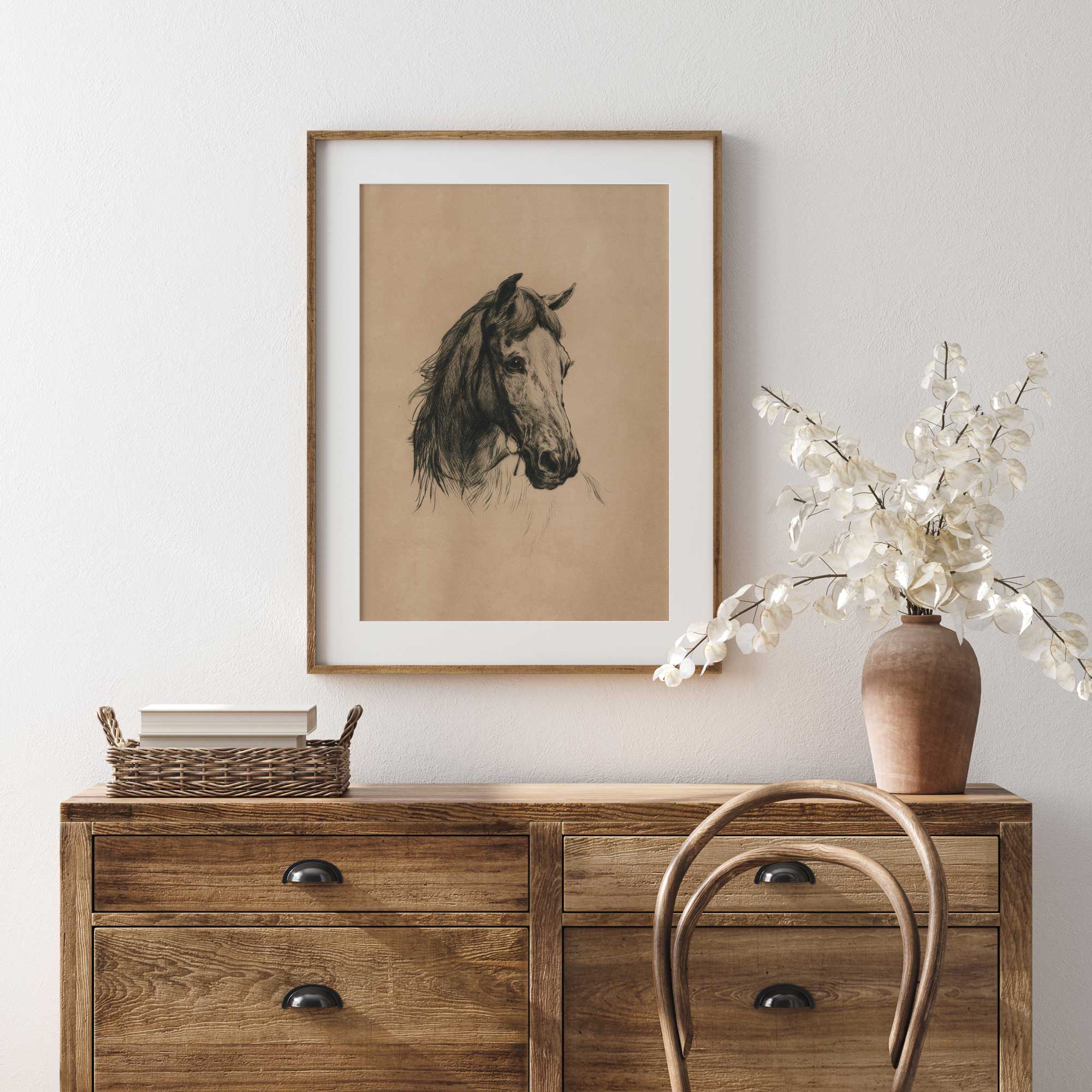 Framed horse portrait above a wooden dresser with a vase and basket.