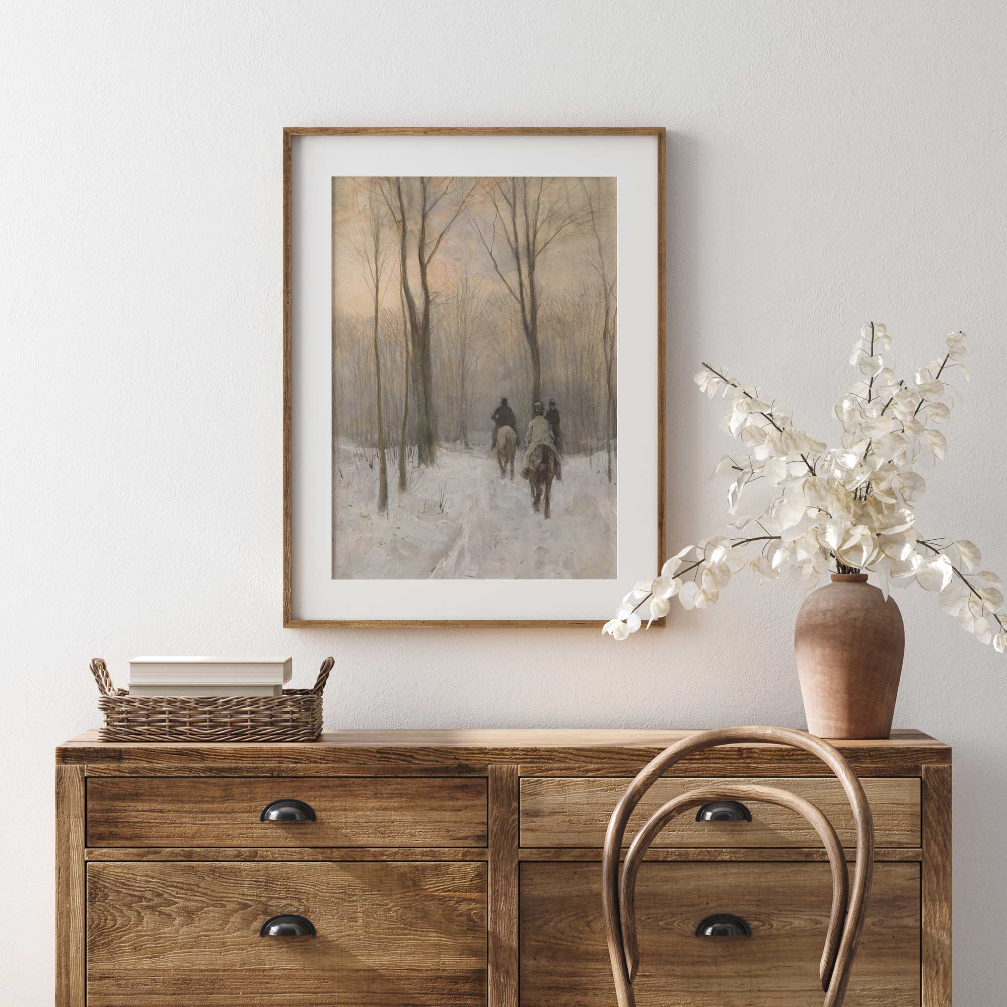 Wooden dresser with framed artwork and decorative items against a white wall