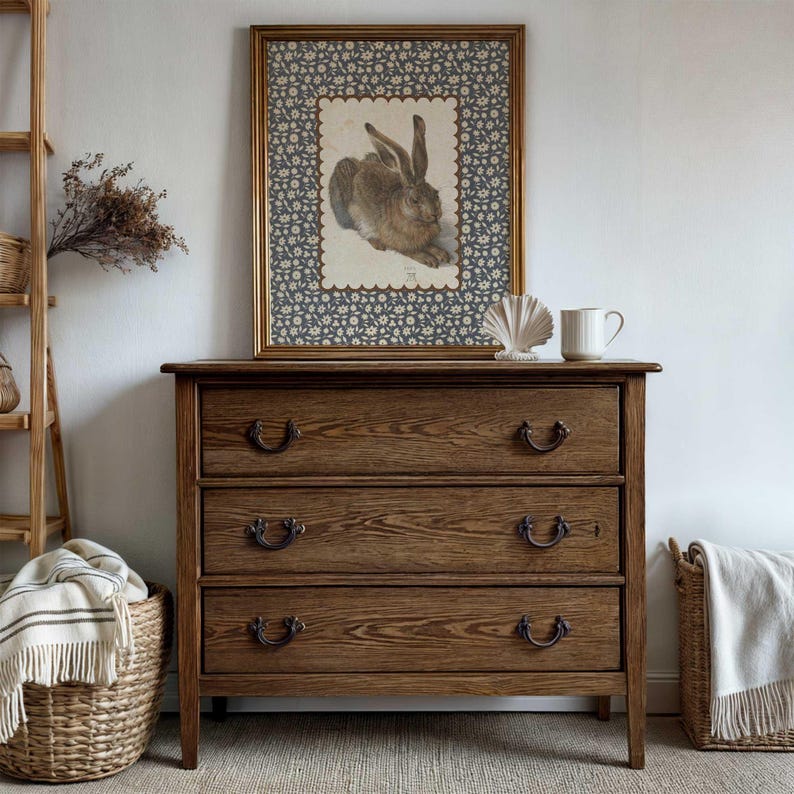 Farmhouse hare print with scalloped border styled on wooden dresser with plant decor.