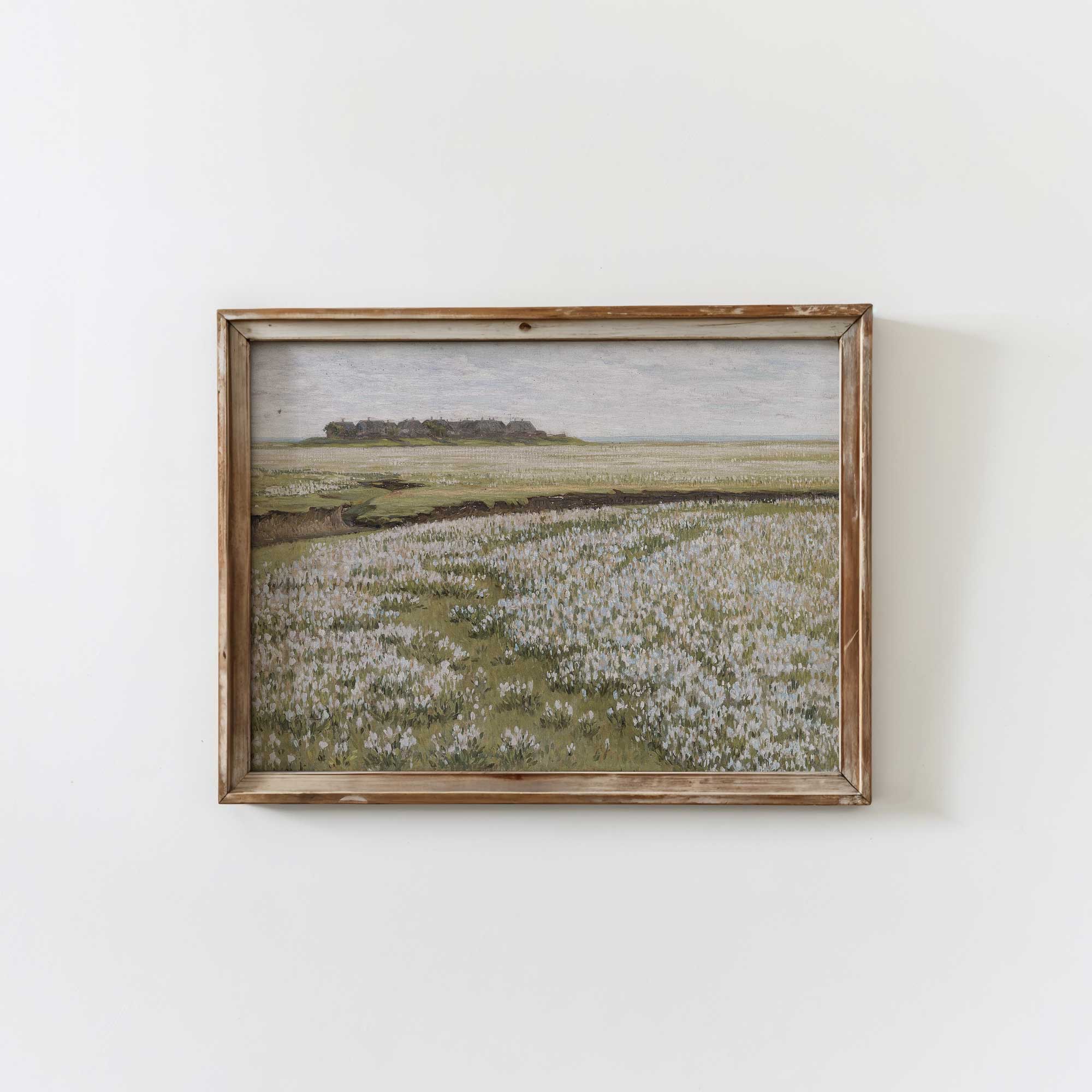 Framed artwork of a landscape with Blooming Floral Meadow on a white wall.