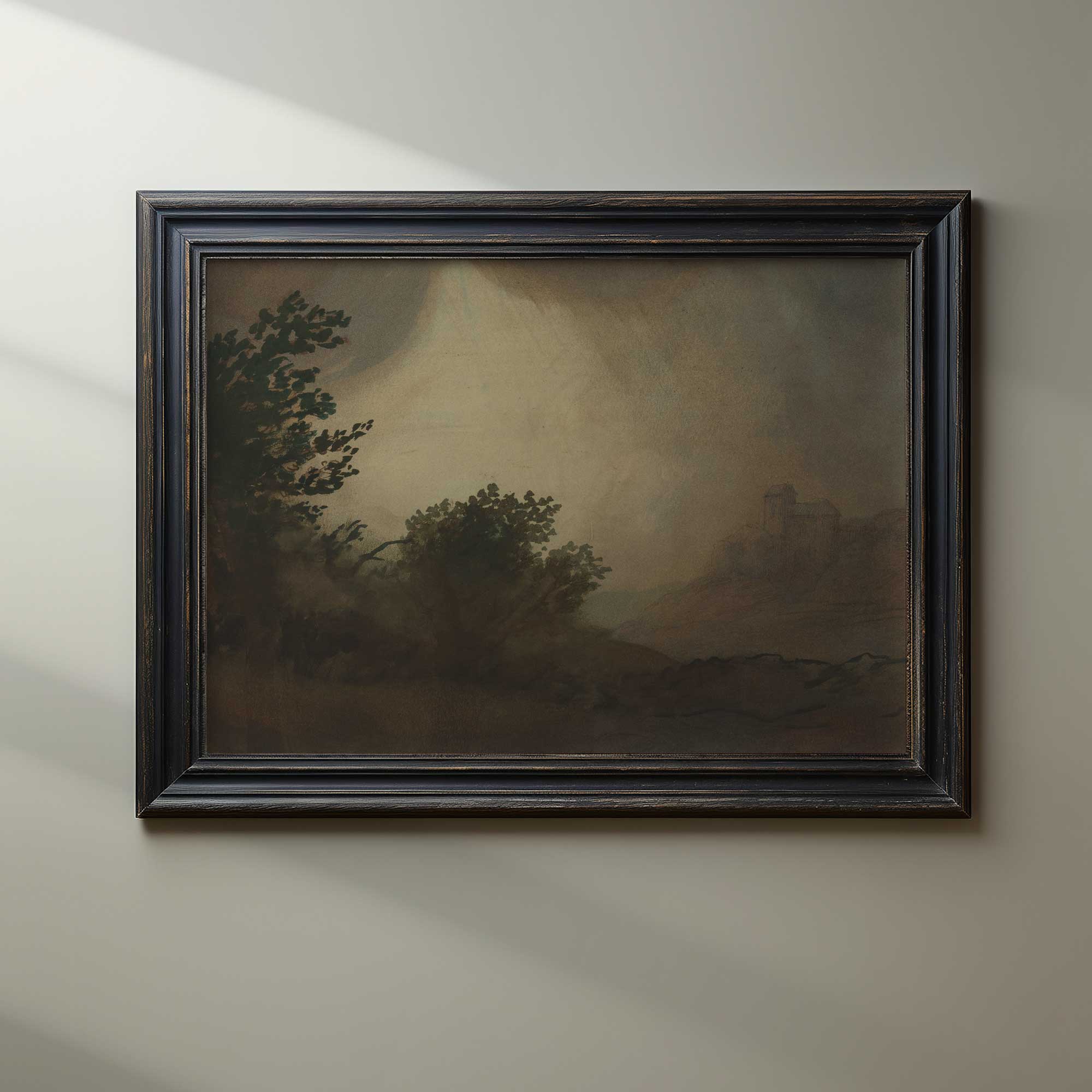Framed Dark Vintage Landscape Print with trees and a mountain on a beige wall.
