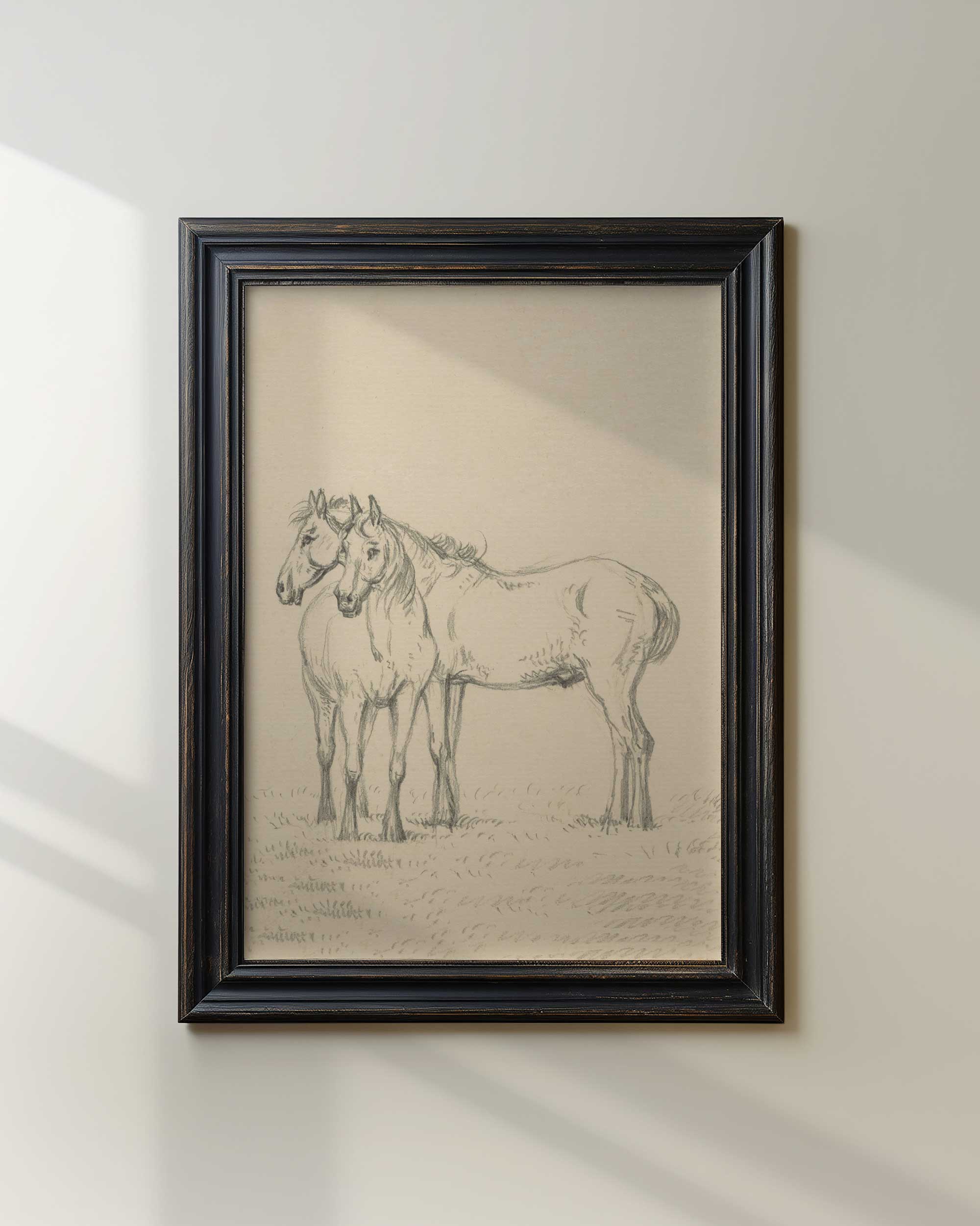 Framed drawing of two horses on a white wall