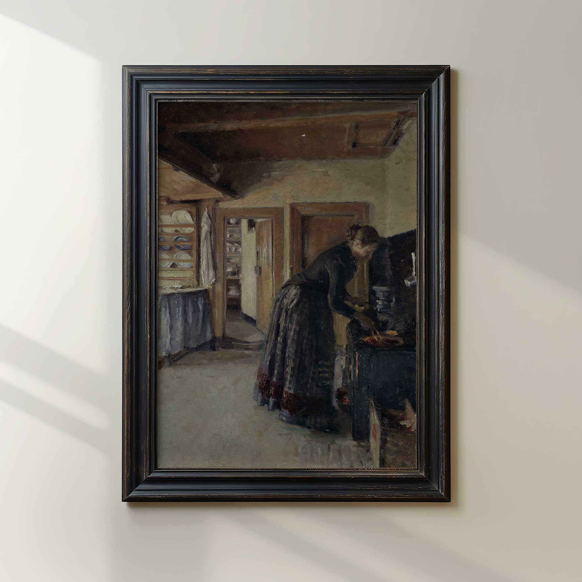 Vintage kitchen scene print in black frame showing a woman preparing food in a farmhouse kitchen
