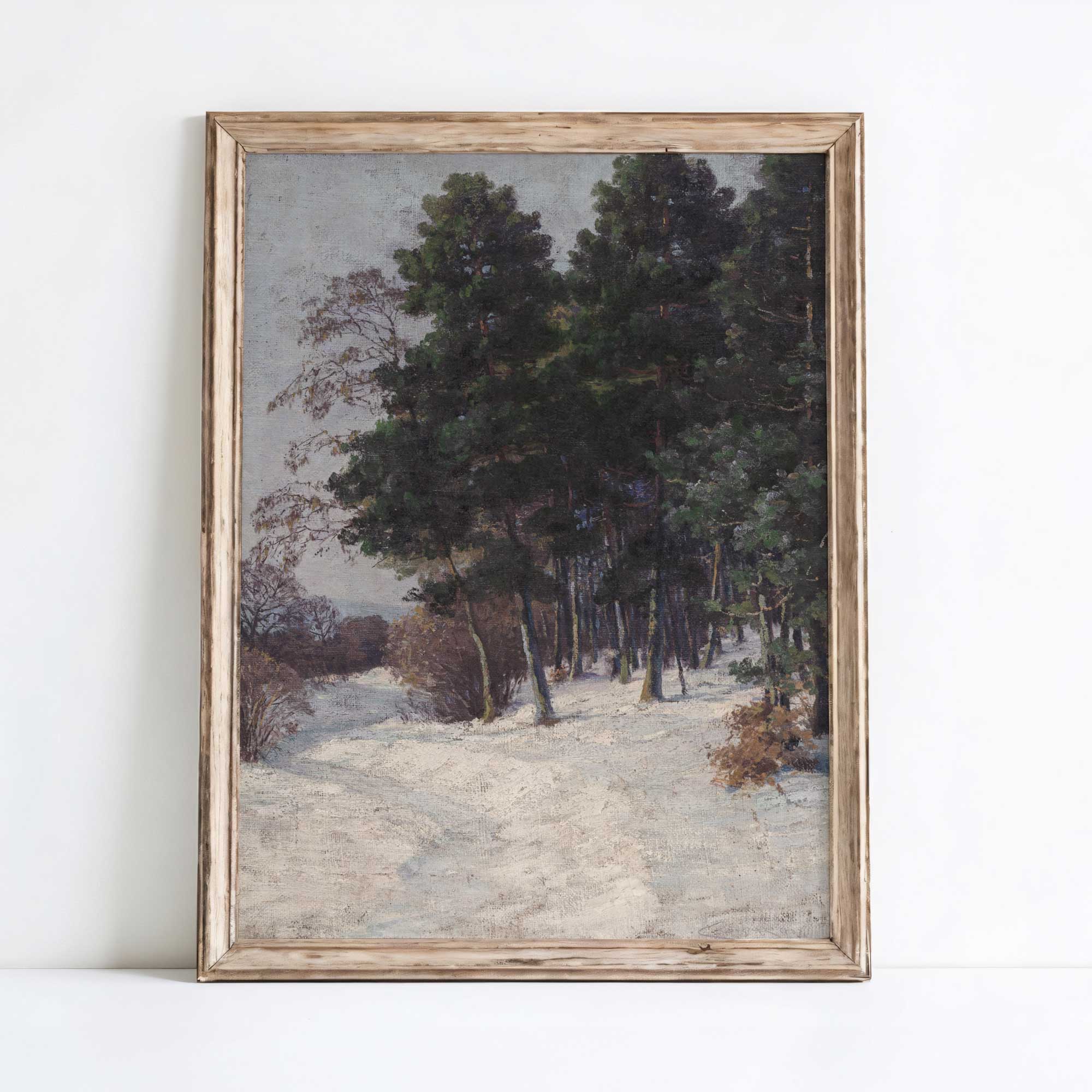 Framed painting of a snowy forest path on a white wall