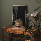 Framed Eclectic Vintage Portrait Print on a wooden table with plants in the foreground