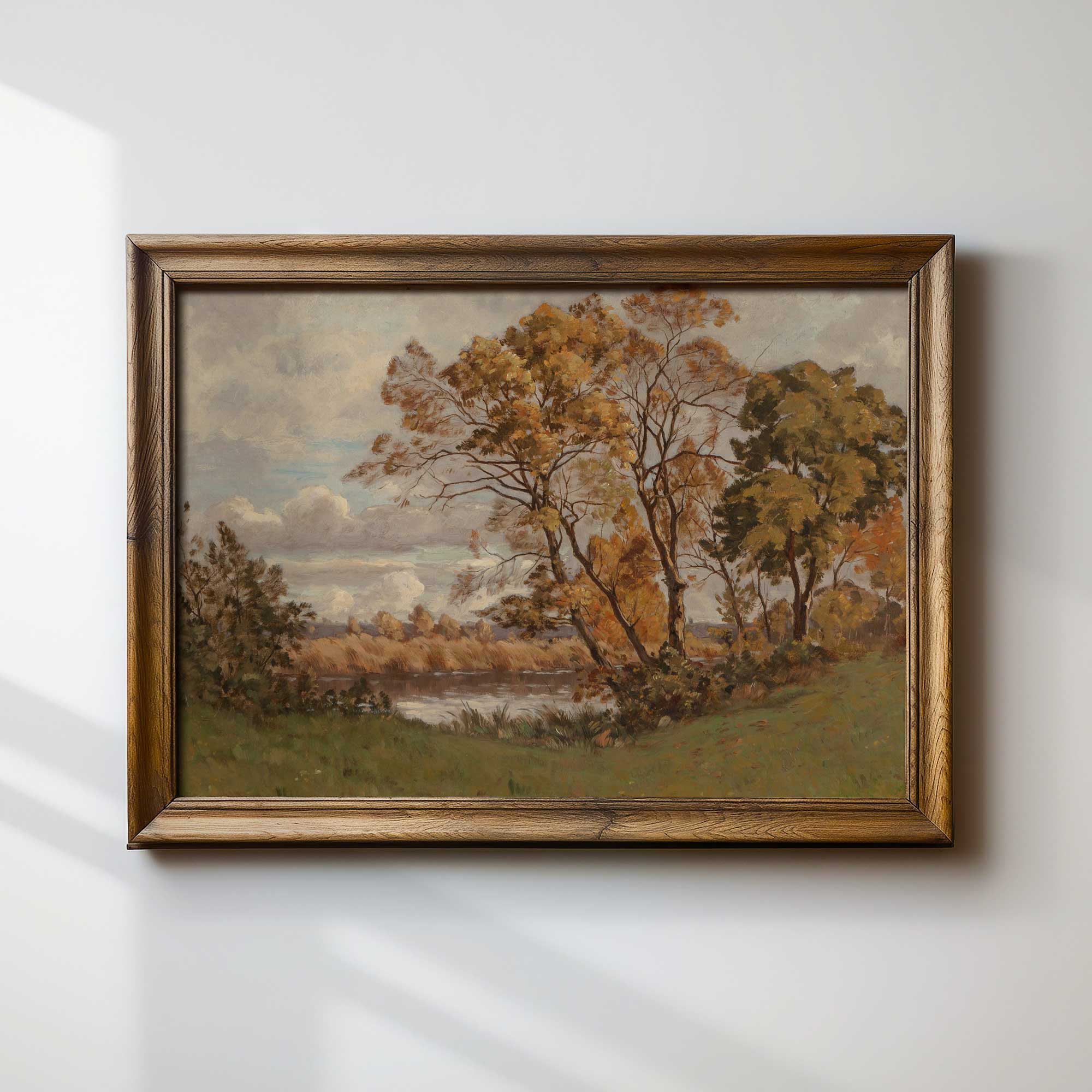 Framed autumn vintage landscape print  of trees and a river on a white wall