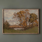 Framed painting of a autumn vintage landscape print with trees and a river on a green wall.
