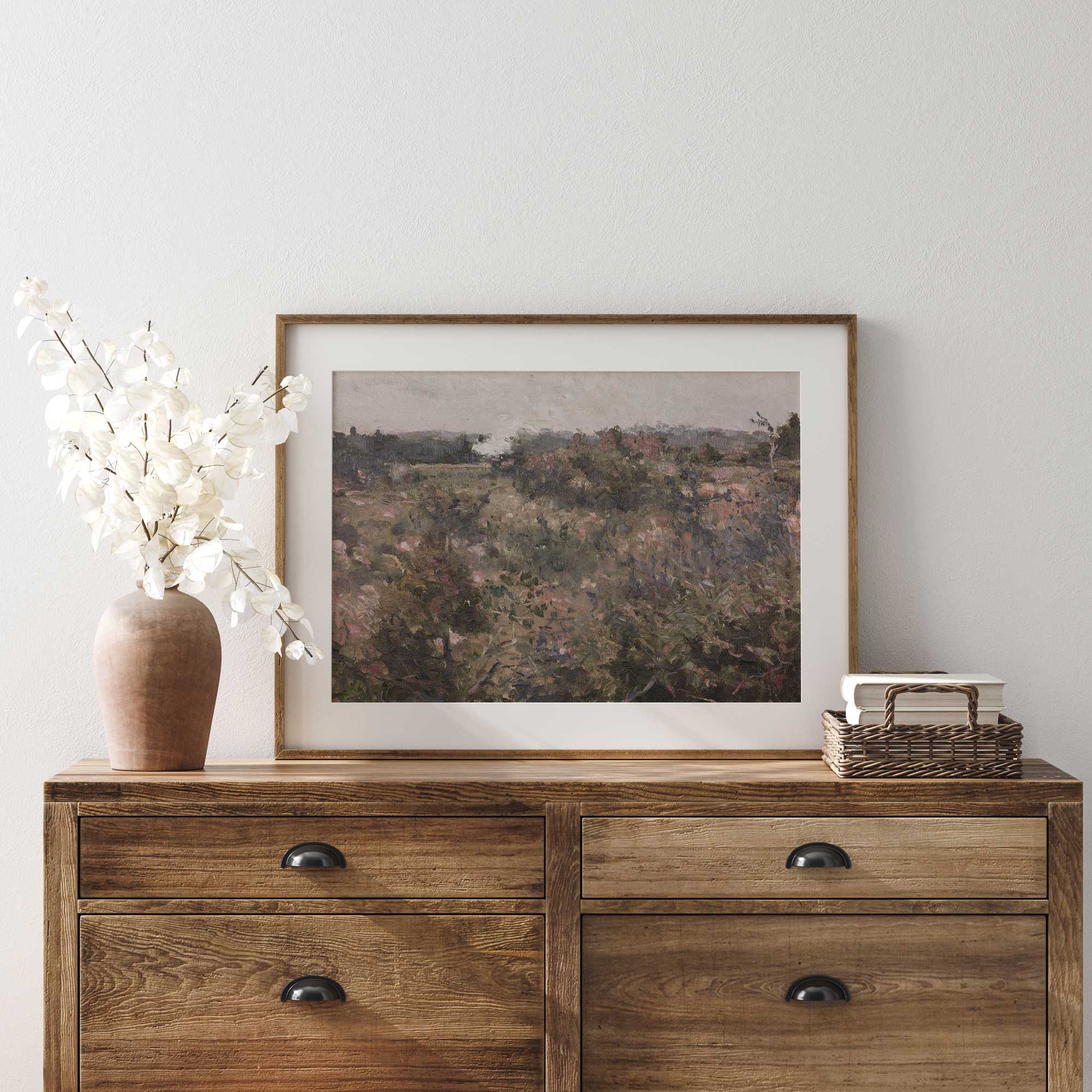 Rustic countryside wall art displayed on a wooden cabinet, featuring a French meadow field print.