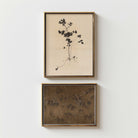 Two framed artworks on a white wall, one with botanical design and the other with The Hundred Horses in Moody dark tones