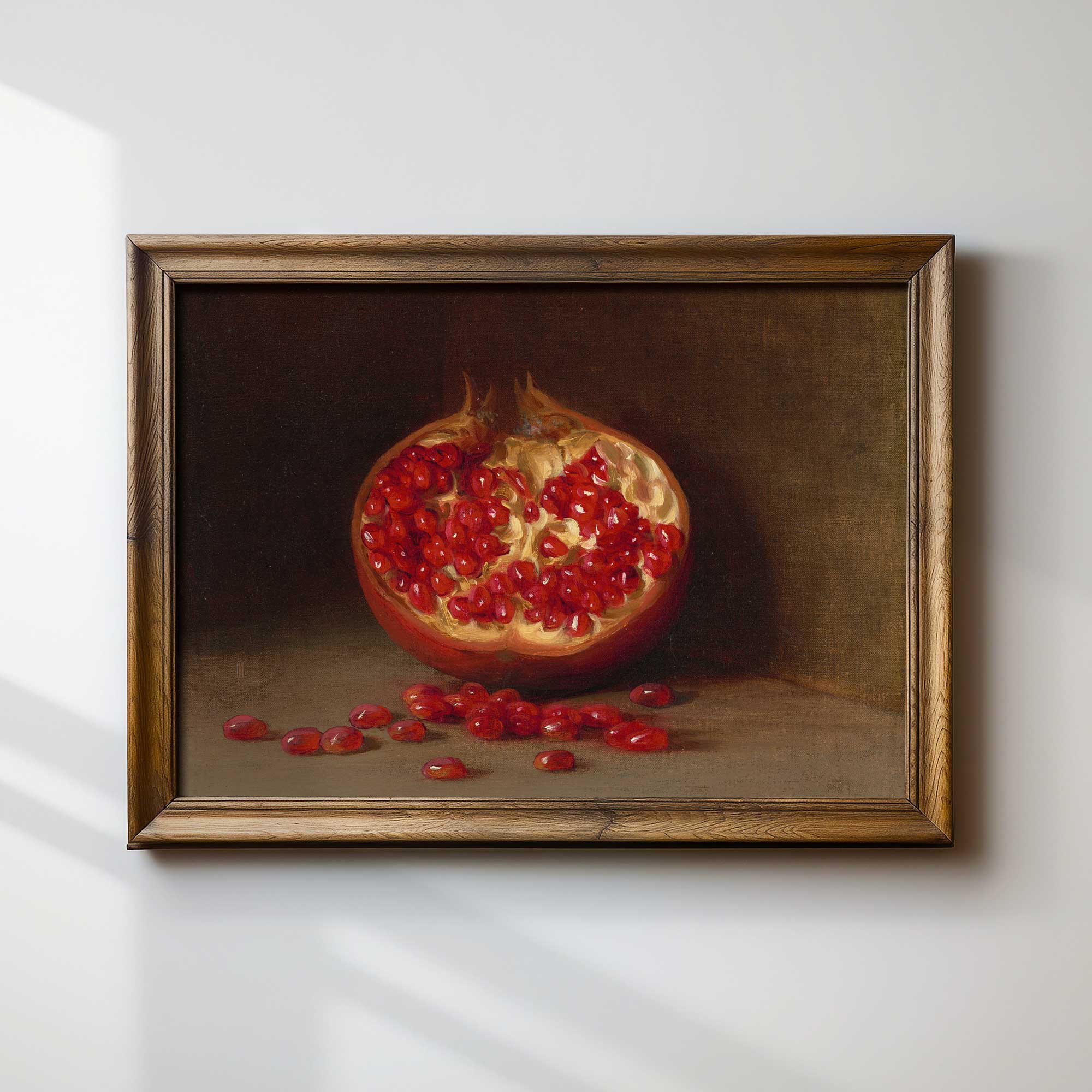 Framed painting of a pomegranate on a white wall