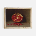Framed painting of a pomegranate with seeds on a dark background