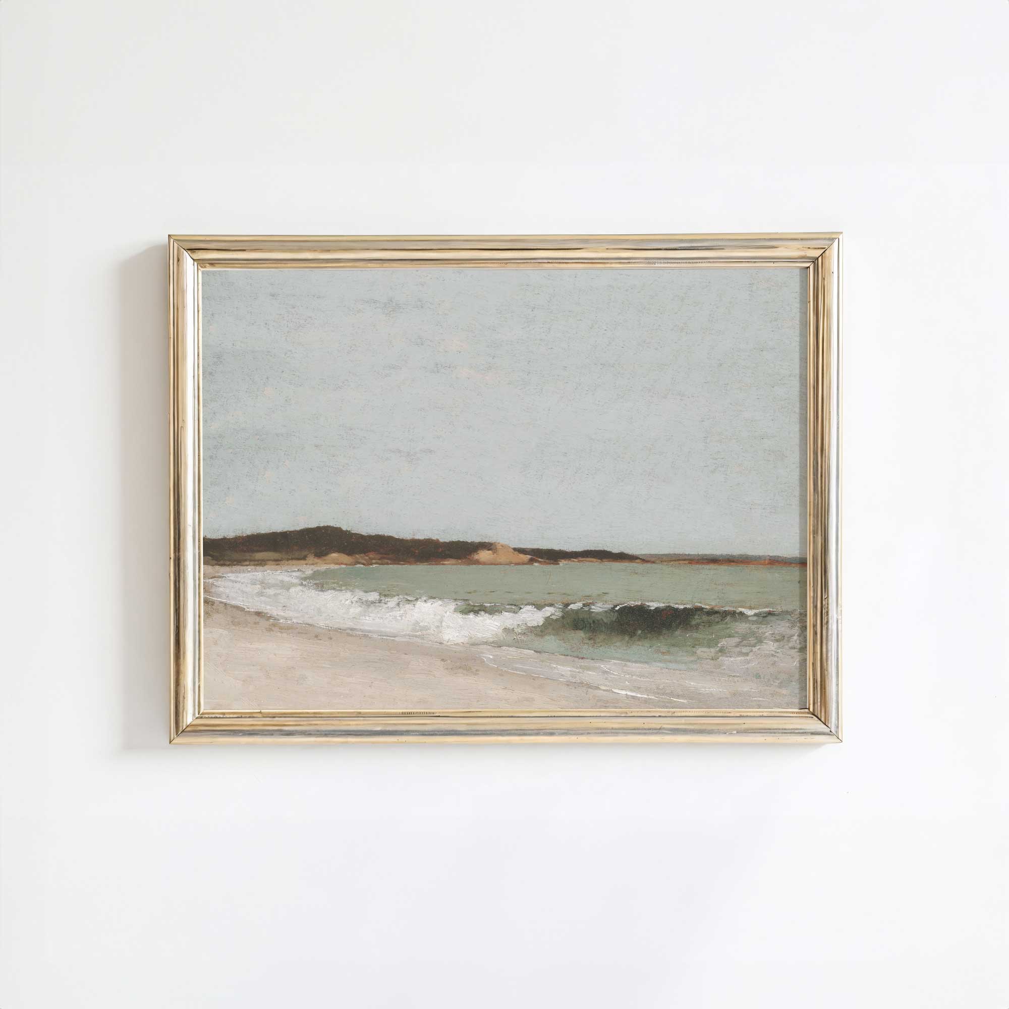 Framed artwork of a vintage coastal scene with a beach and ocean on a white wall.