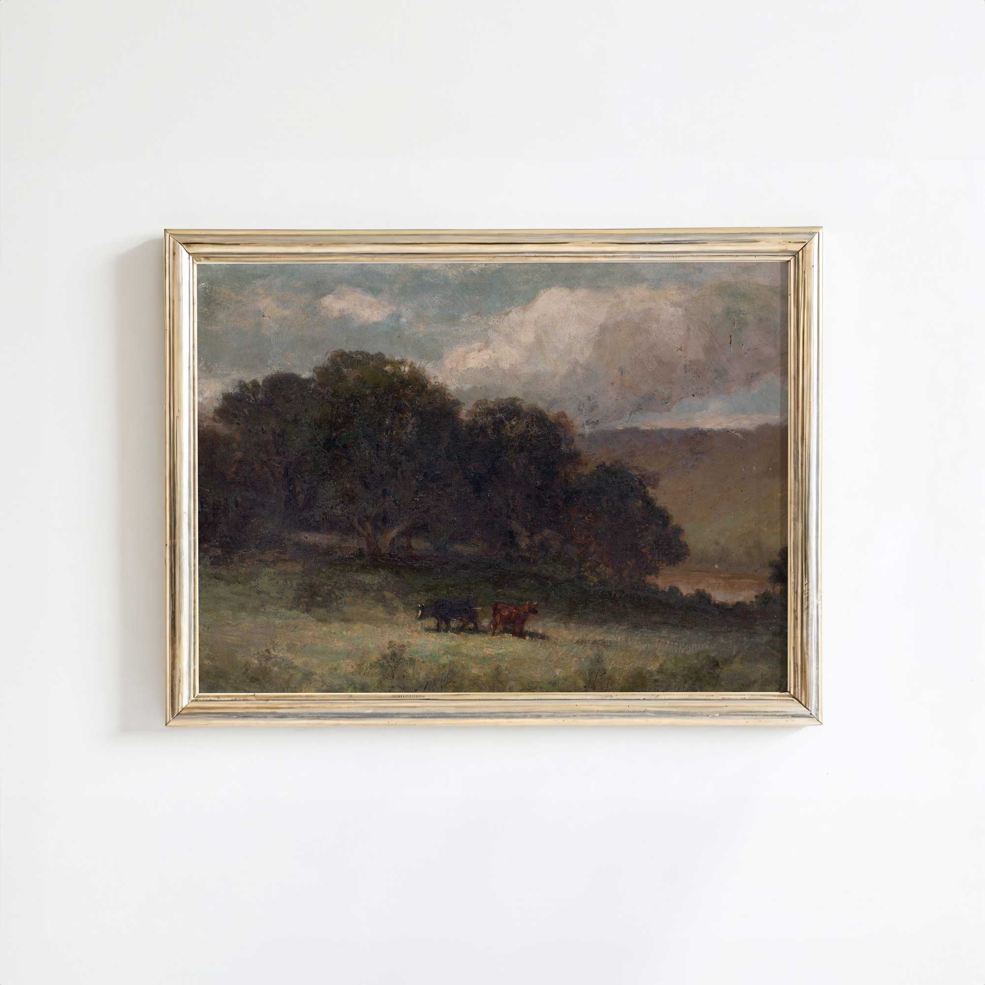 Vintage moody landscape print in an antique gold frame featuring a pastoral countryside scene with grazing cattle