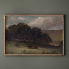 Vintage moody landscape print with grazing cows displayed in a rustic wood frame against a dark green wall