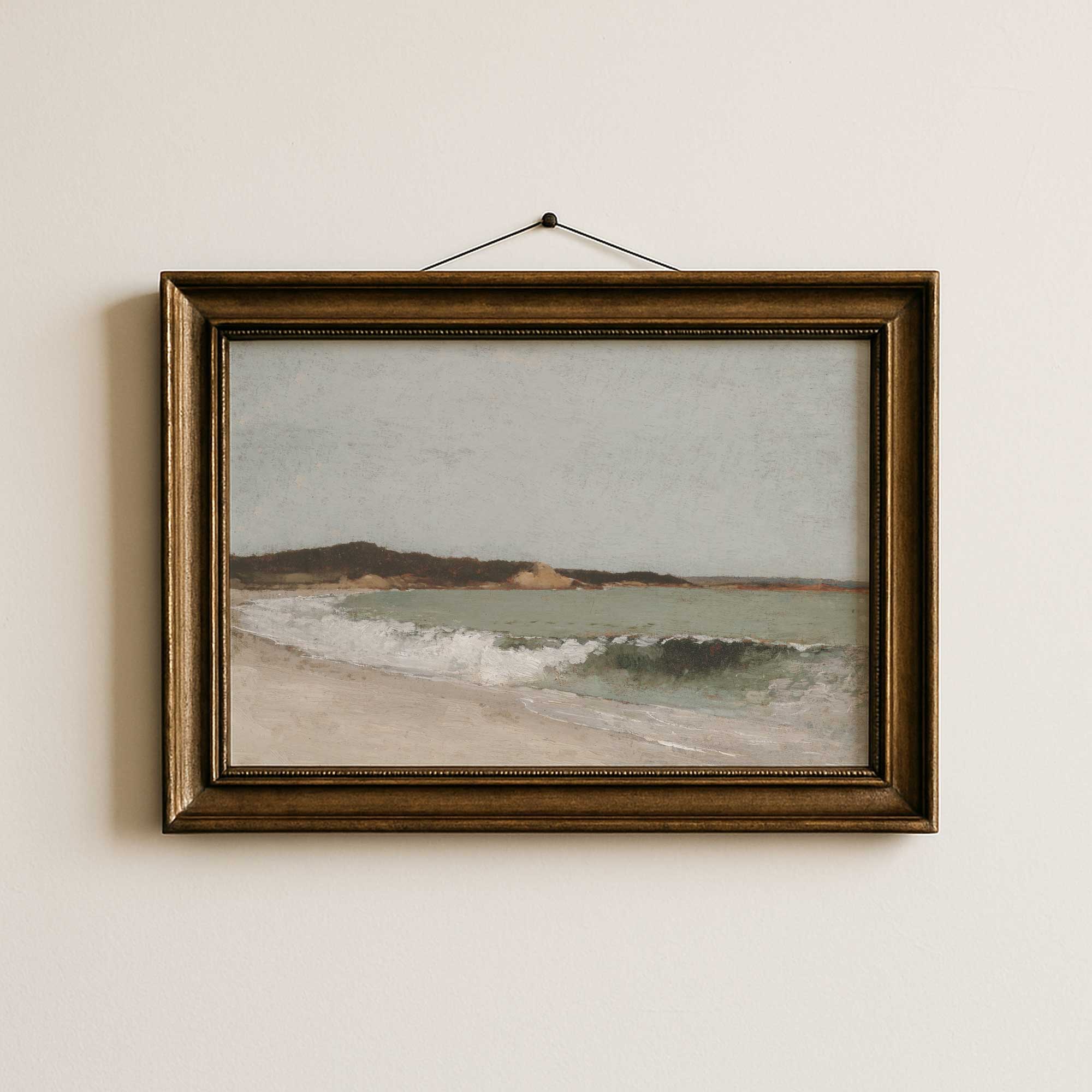 Framed painting of a vintage beach scene on a beige wall