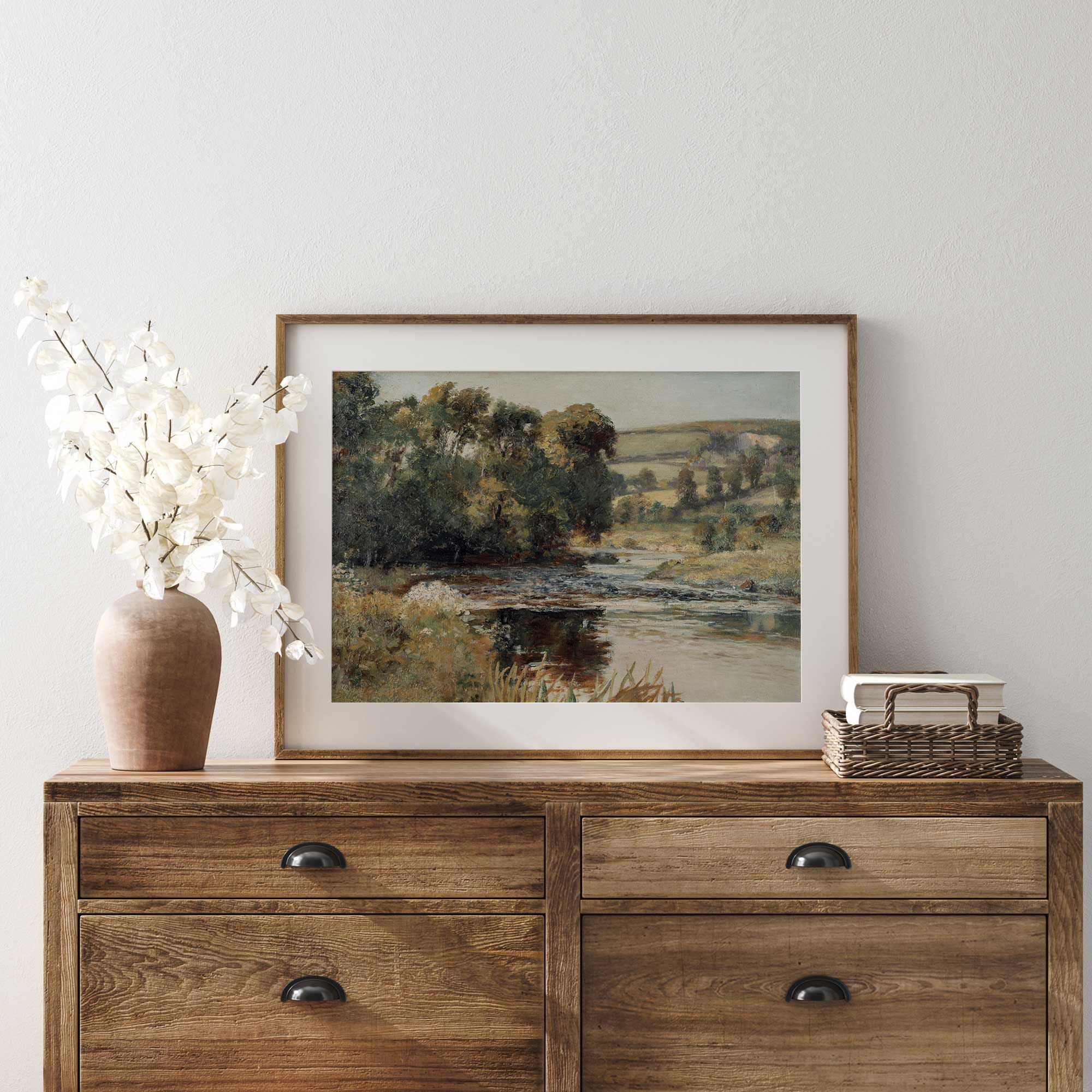 Vintage summer landscape print displayed above a rustic dresser in a farmhouse interior.