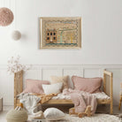 Whimsical folk art house print in gold frame displayed in the Nursery