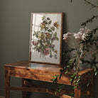 Framed botanical print on a wooden table with a dark green wall background