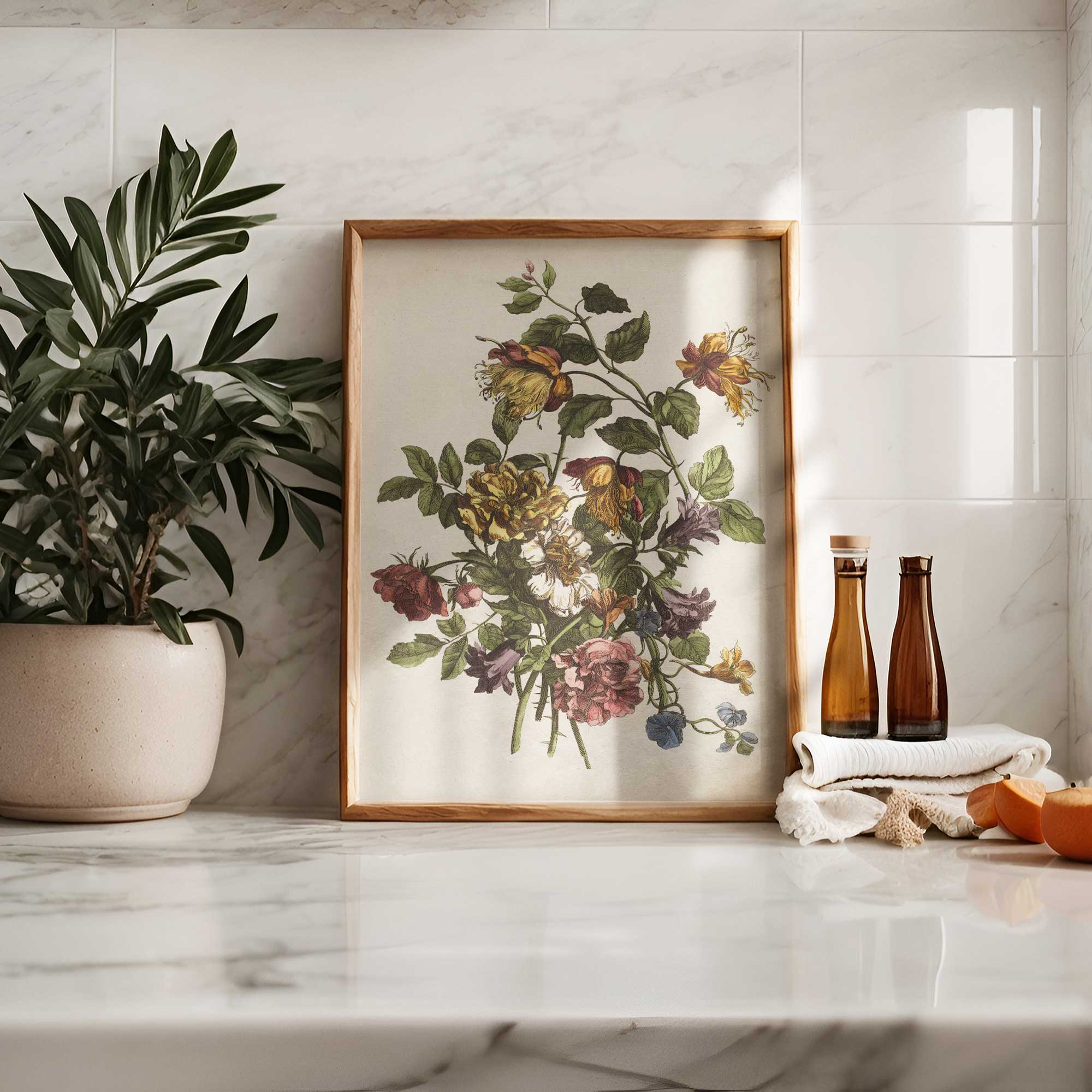 Framed floral print on a marble surface with a plant and bottles in the background