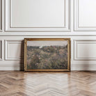 Framed  French Meadow Field Landscape Print on a wall with decorative paneling and wooden floor