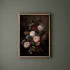 Framed painting of flowers on a dark background against a green wall