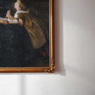 Close-up view of Mother and child reading print in gold frame.