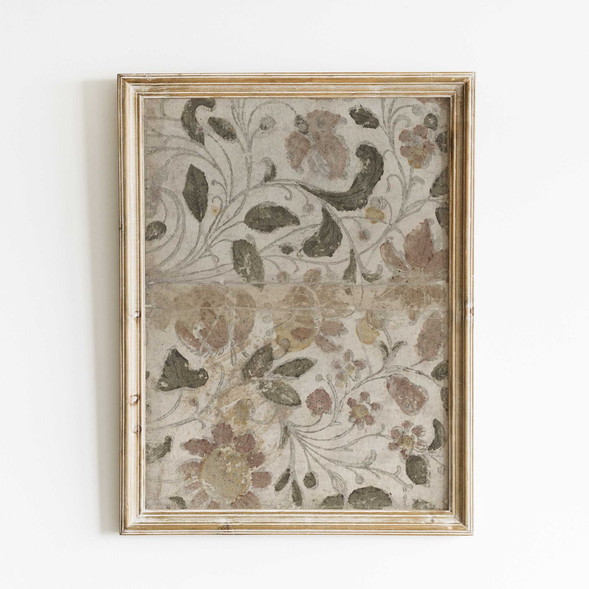 Decorative floral patterned fabric in a gold frame on a white background