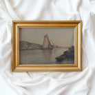 Framed artwork of a sailboat scene on a white fabric background