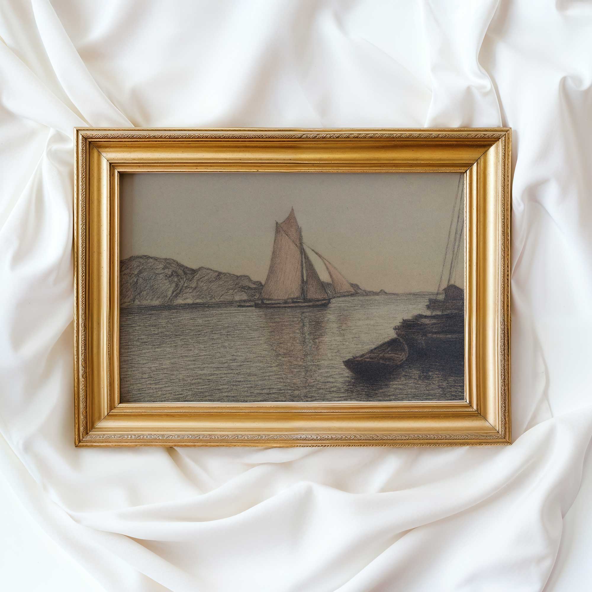 Framed artwork of a sailboat scene on a white fabric background
