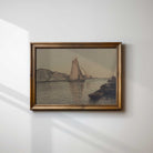 Framed artwork of a sailboat on water with mountains, on a white wall.