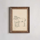 Framed artwork of two horses on a textured wall